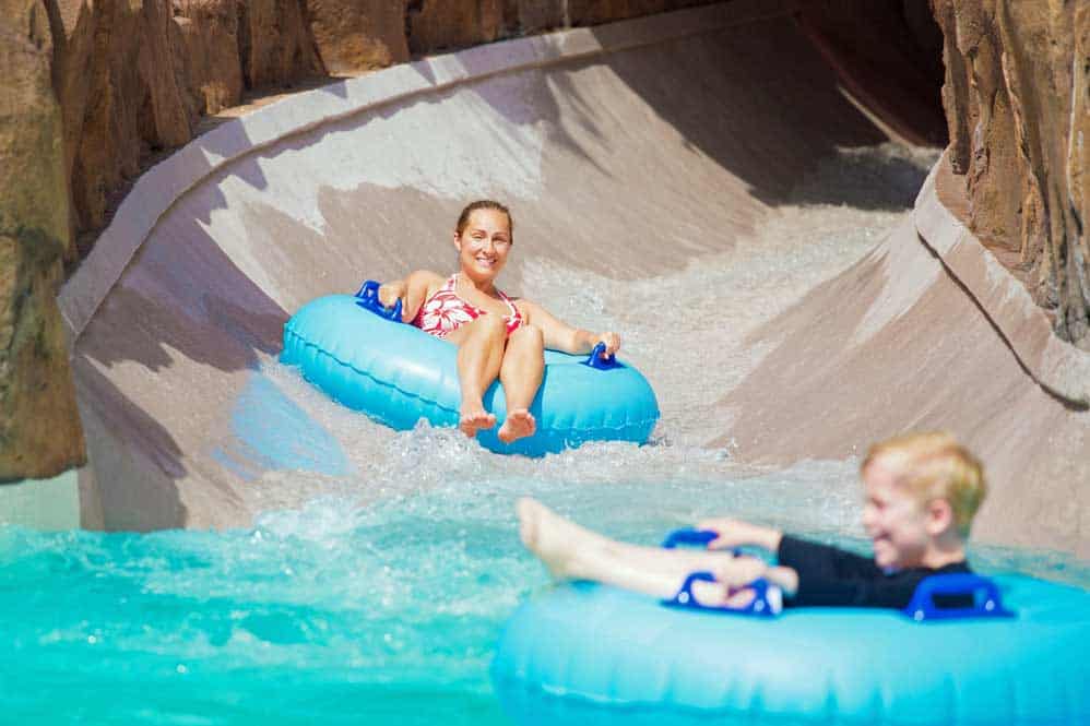 Photo of a woman and child tubing down a water park slide